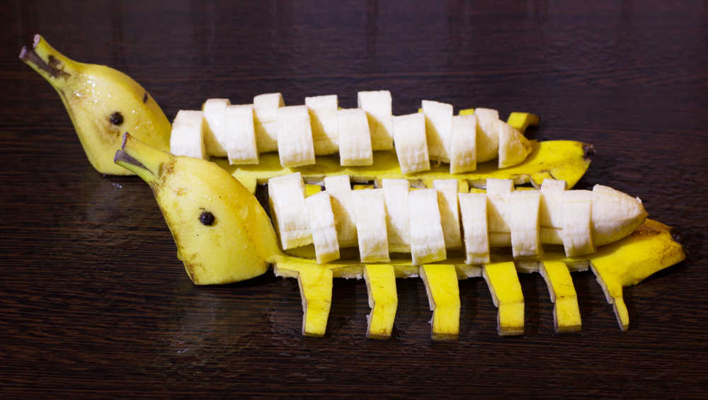 Bananas sliced and sitting on banana skins shaped like ducks.