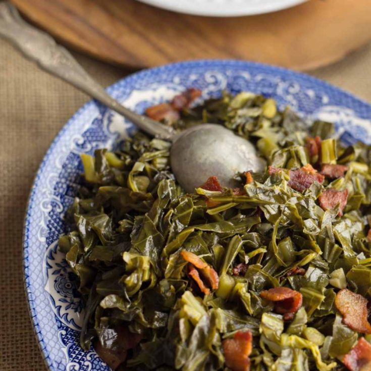 Sautéed Brussels sprouts leaves with bacon in a serving dish with a spoon.