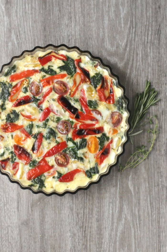 Egg white quiche - crustless base sitting on a wooden board with fresh herbs.