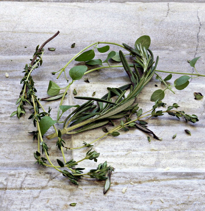 Fresh thyme, oregano and rosemary on a counter.