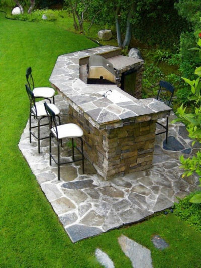 Outdoor kitchen with flagstone and stacked stone.