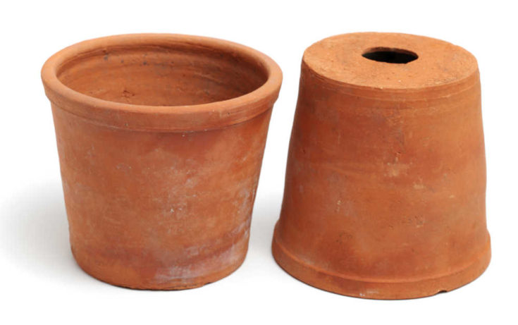 Terra cotta pot upside down with drainage hole showing.