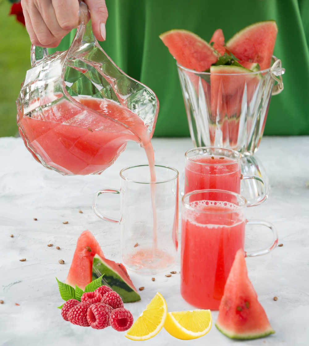 Pouring watermelon lemonade with raspberries.