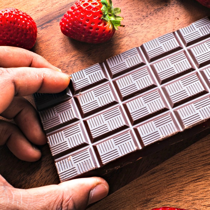 bar of cgicikate and fresh strawberries