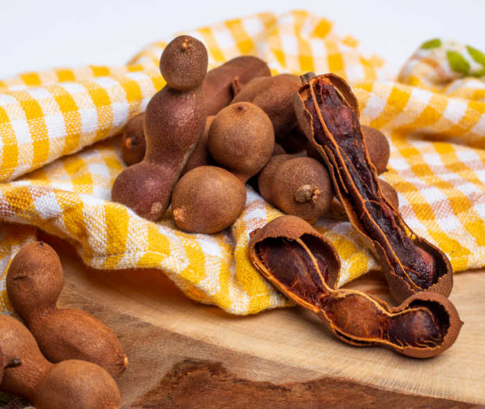Tamarind pods on a yellow checked towel.