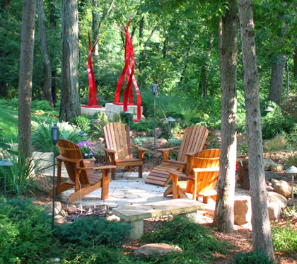 Rustic patio with lush trees around it.