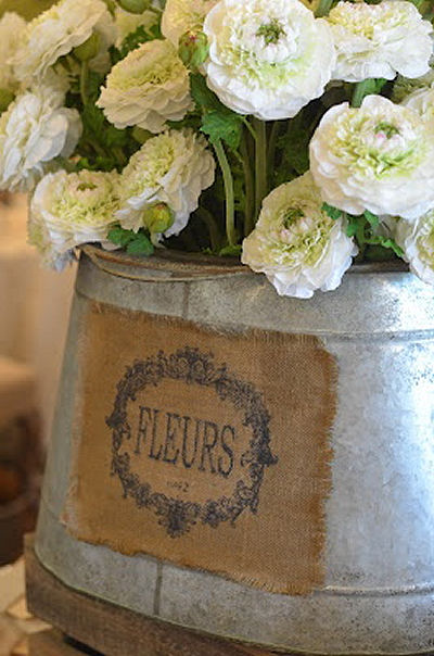 Galvanized bucket with burlap, perfect for Spring flowers on a farmhouse porch!