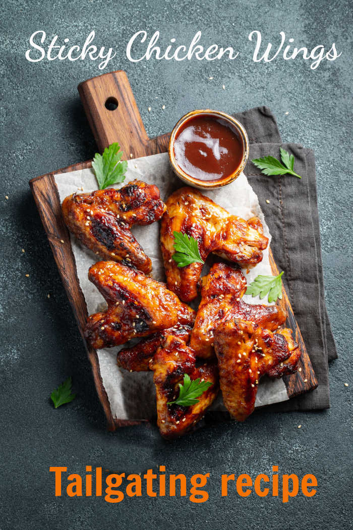 Sticky chicken wings with sauce on a cutting board with text reading Sticky Chicken Wings - Tailgating Recipe