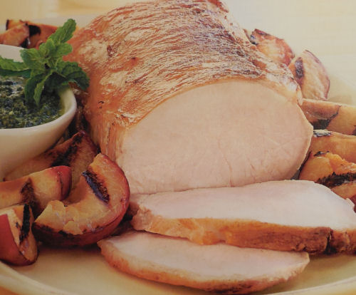 Roasted pork loin with mint sauce and plums.