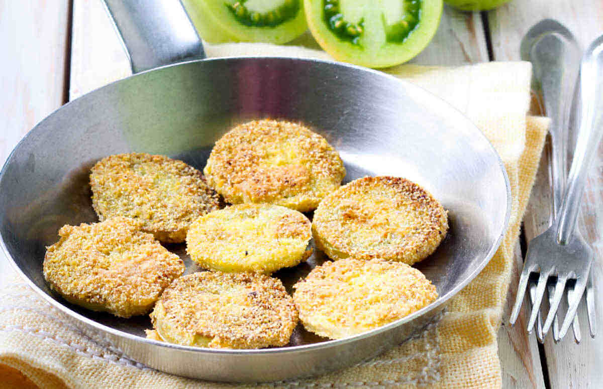 Fried green tomatoes in a frying pan.