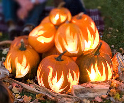 Flame Pumpkins in a log setting for a perfect fire scene.