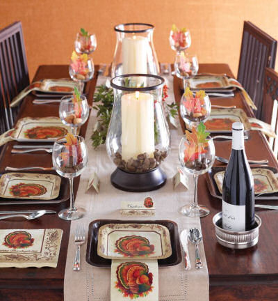 Thanksgiving tablescape with colorful napkins and leaves in wine glasses
