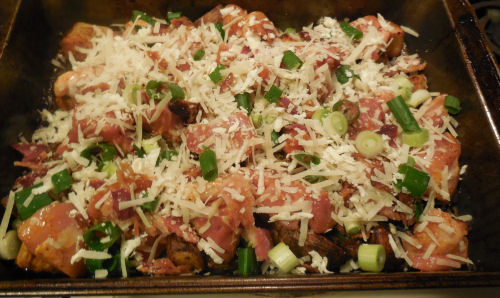 Chicken and cheese on top of potatoes and ready to cook.