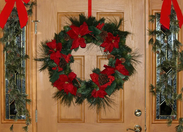 Traditional Christmas Wreath with red bows on a front door.