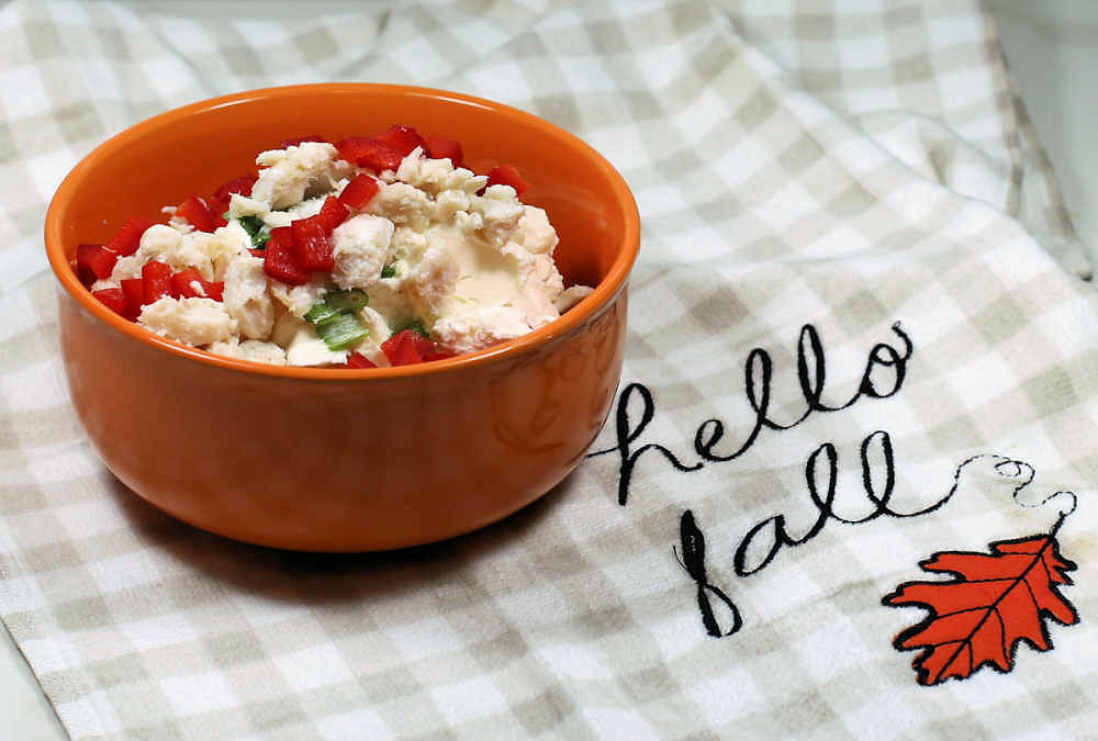 Orange bowl with cream cheese, red peppers, onions and crabmeat and tea towel with words Hello fall.