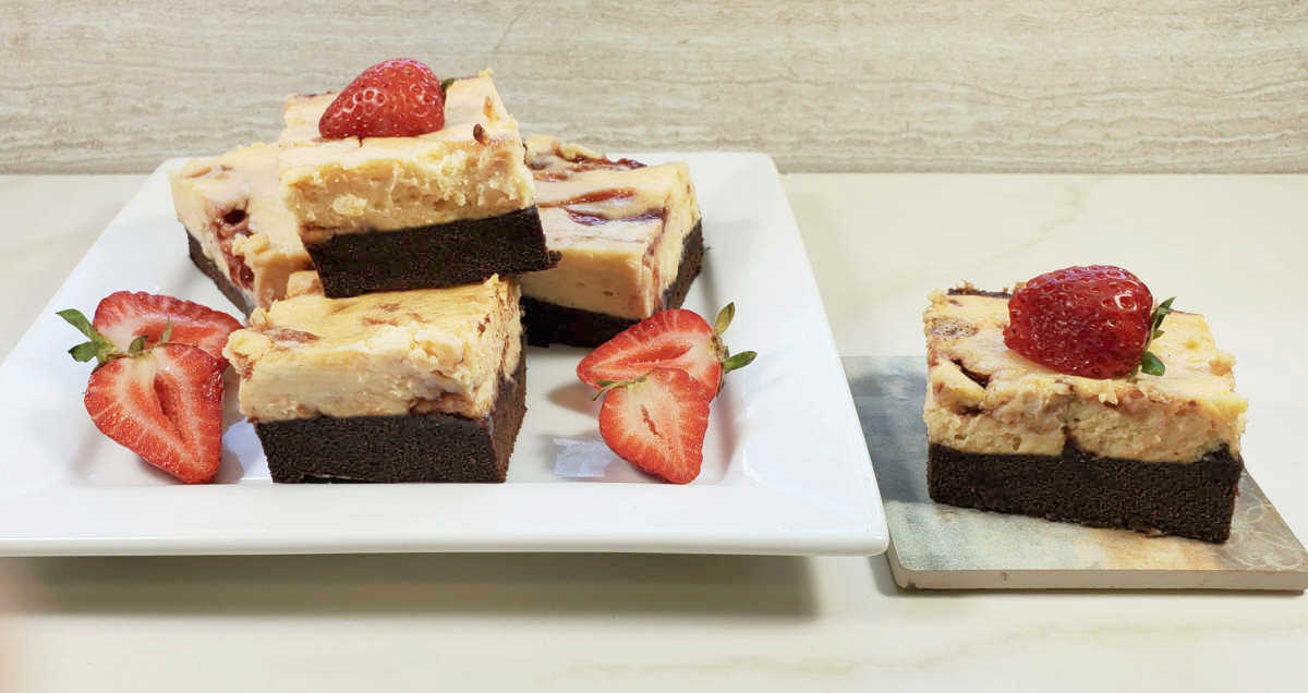 Cream cheese swirl brownies with sliced strawberries.
