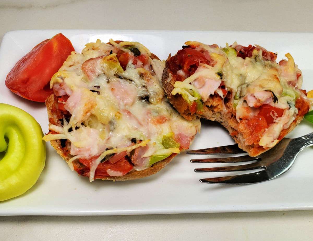 Breakfast pizzas on a white plate with a fork.