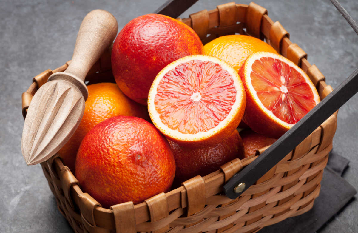 Pink grapefruit in a basket with a juicer.