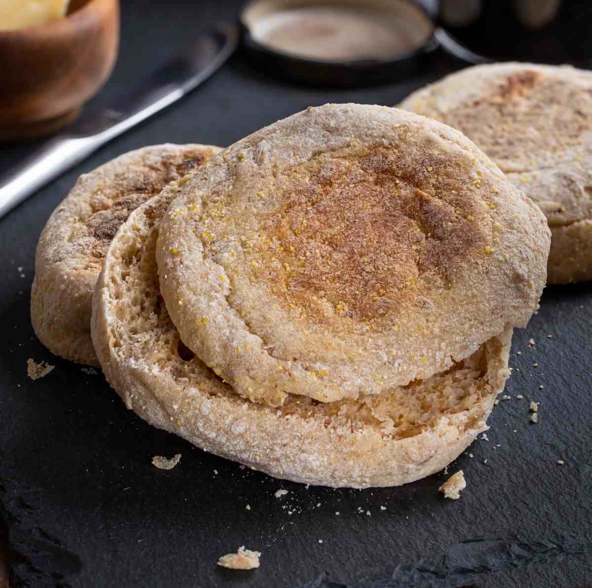 Split English muffins on a slate counter.