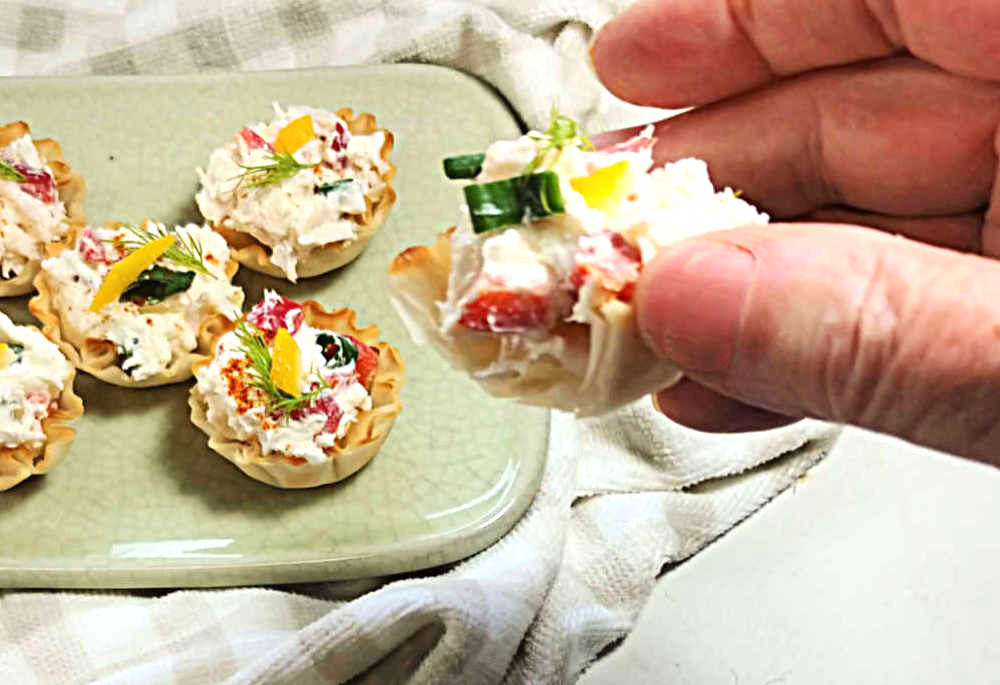 Hand holding a Phyllo cup appetizer.