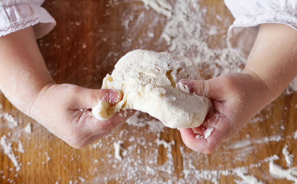 Child hands kneading homemade play dough.