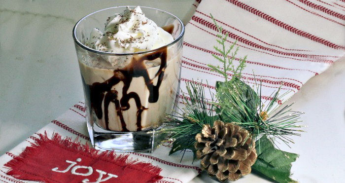 Mudslide cocktail made with Baileys Irish Creamon a Joy towel near a pine cone.