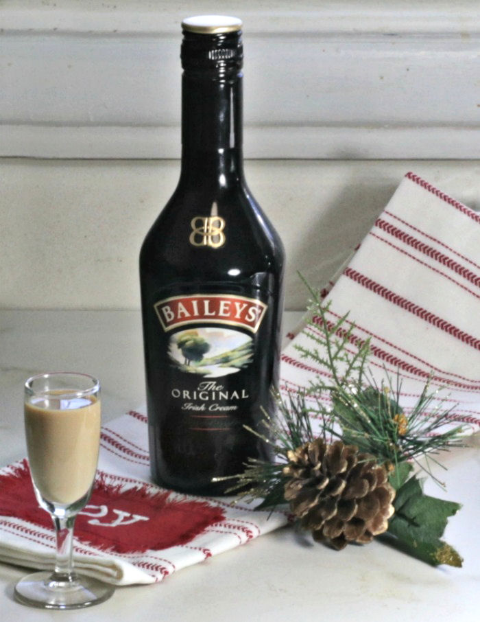 Shot of Bailey's Irish Cream with a bottle, towel and pine cone.