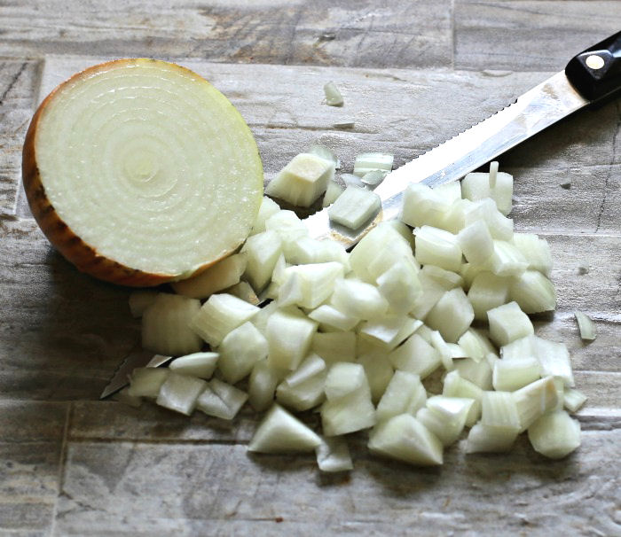 Chopped onions for a potato salad with bacon and pickles