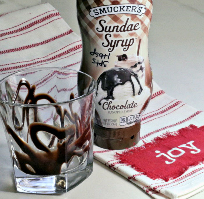 drizzled glass with chocolate syrup and Joy towel.