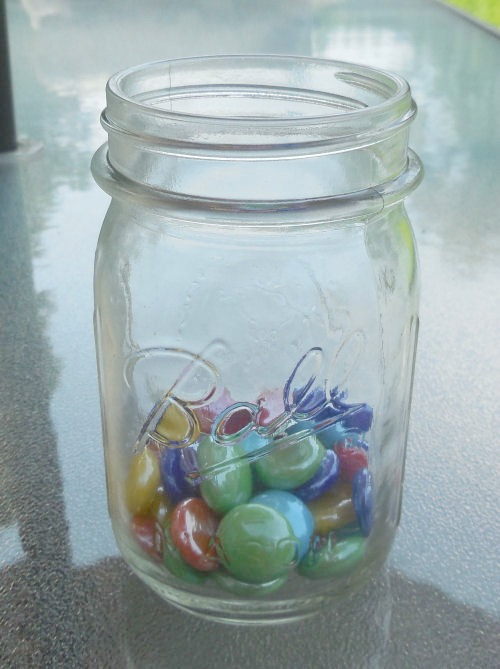 Rocks fill the bottom of the mason jars to anchor the flower cuttings.