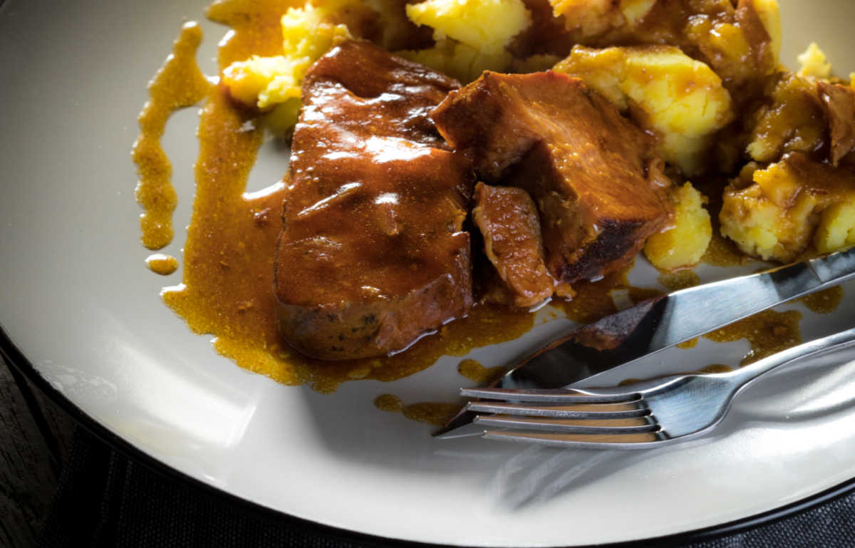 pork roast with fork on a white plate.