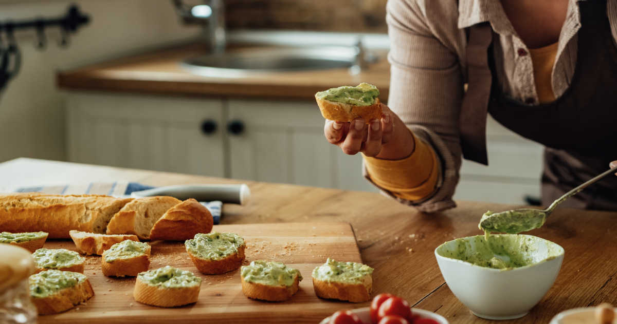 Woman making avocado toast.