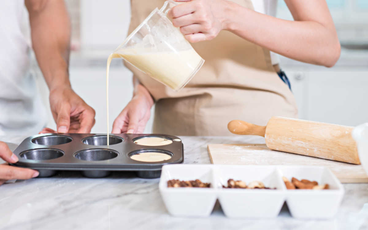 Pouring batter into muffin tins.