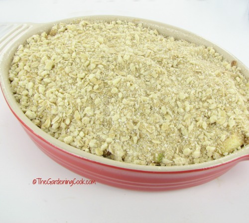 Gluten free apple crumble in a red pan ready to cook.