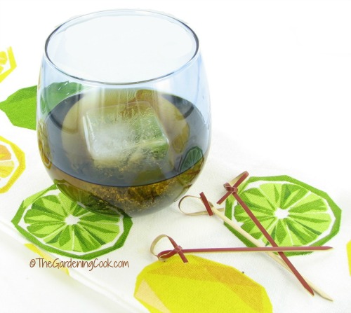 large frozen ice cube in a glass with cocktail sticks and a pretty napkin.
