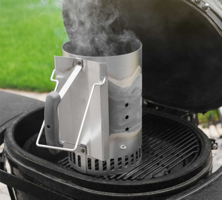 Charcoal chimney starter on a grill.