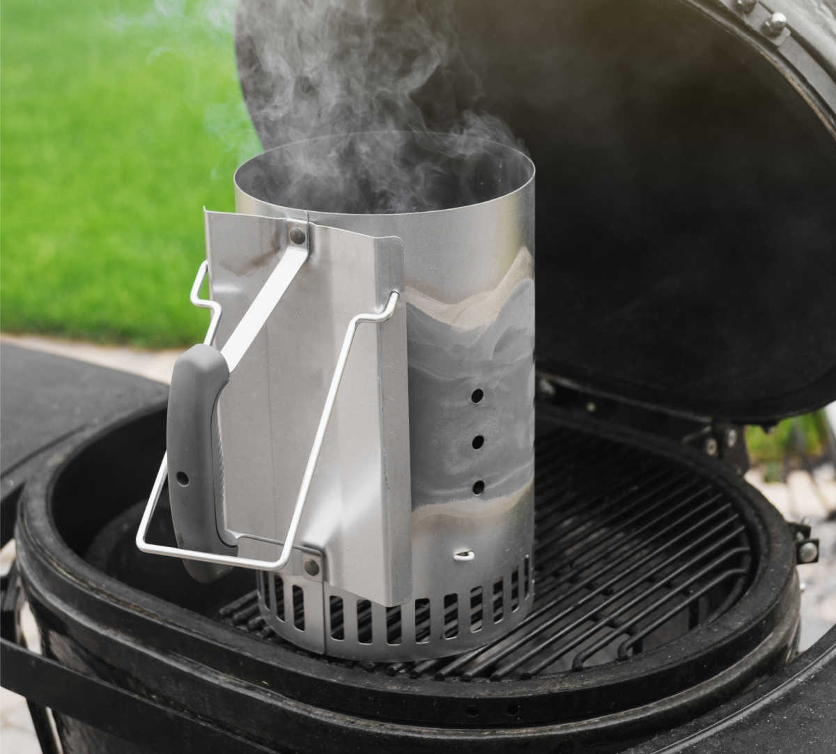 Charcoal chimney starter on a grill.