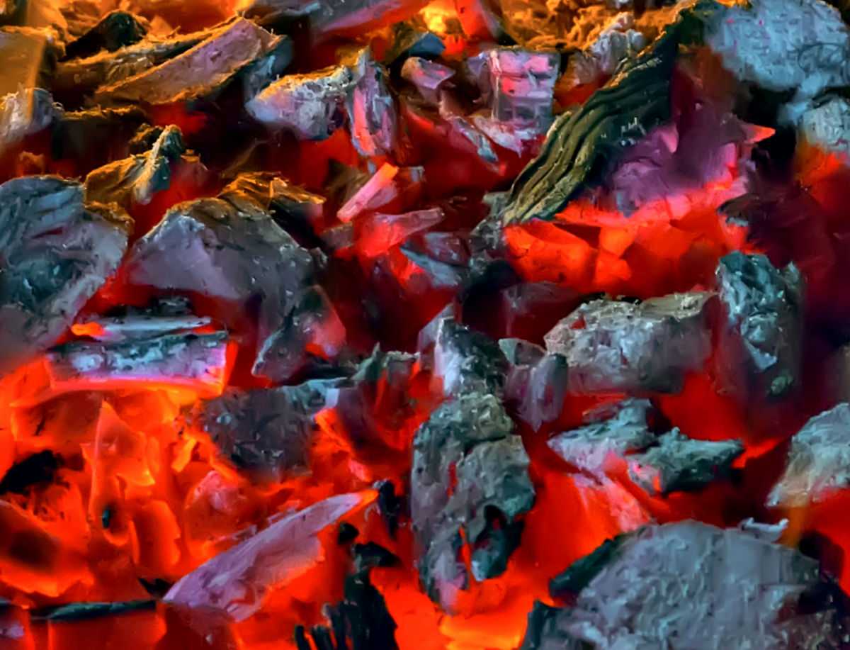 Burning embers of a charcoal fire.