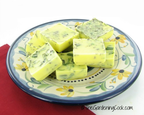 Frozen fresh herbs in olive oil o a blue and yellow plate.