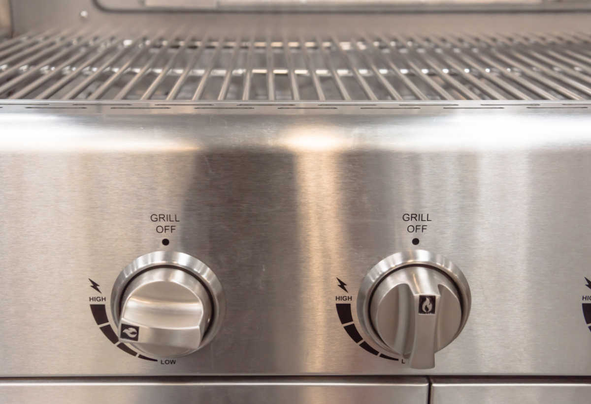 Gas barbecue knobs set to preheating before cooking.