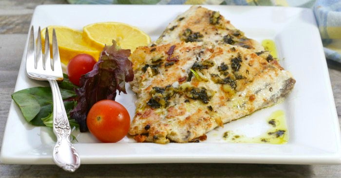 barramundi on a plate with salad and a fork.