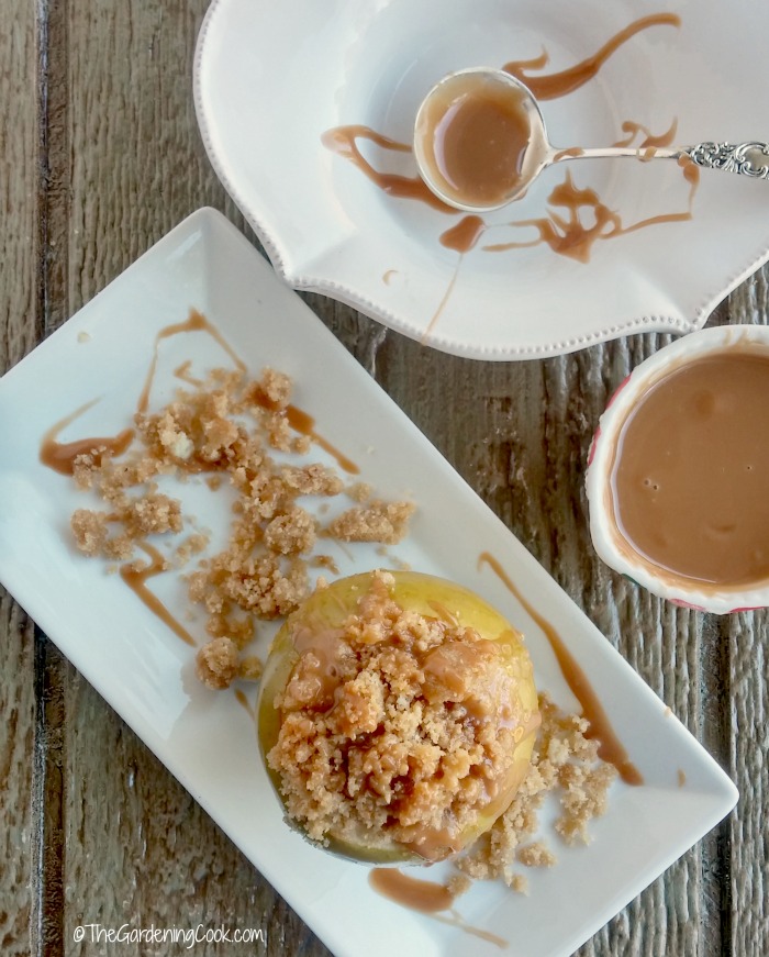 Apple crumble baked apples with caramel topping. Apple crumble baked apples with caramel topping on white plates and bowls.