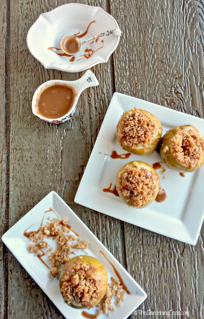 apple crumble baked apples Apple crumble baked apples with caramel topping on white plates.