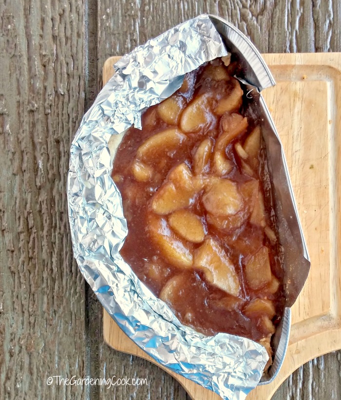 Half and apple pie. Half an apple pie ready to cook on a cutting board.