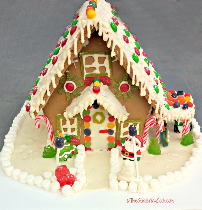 Gingerbread house with frosted roof and candy decorations. 