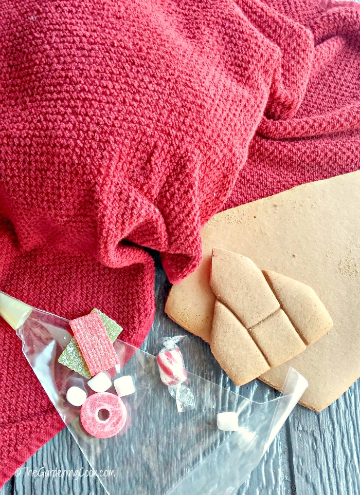 gingerbread pieces, candy, icing bag and clean tea towel.