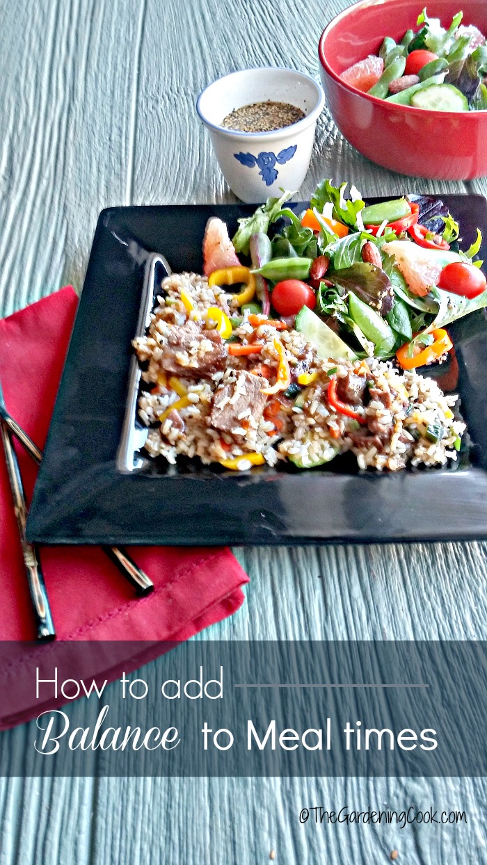 Salad with dressing and black plate with a healthy meal, red napkin and words reading How to add balance to meal times.