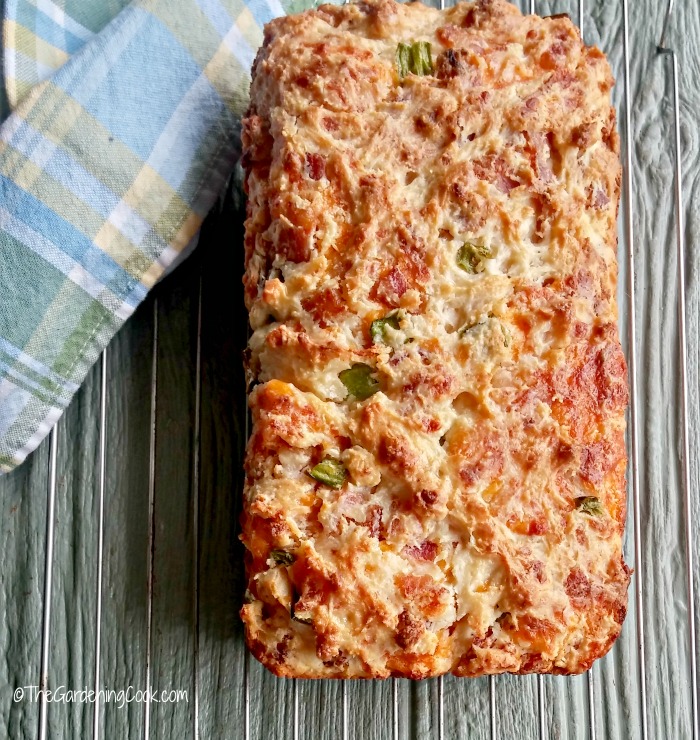 Bacon jalapeno cheese bread on a rack with a blue checked napkin.