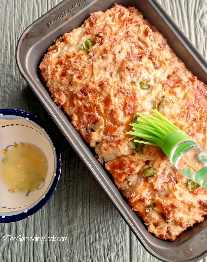 Adding butter to the top of the Bacon jalapeno cheese bread.