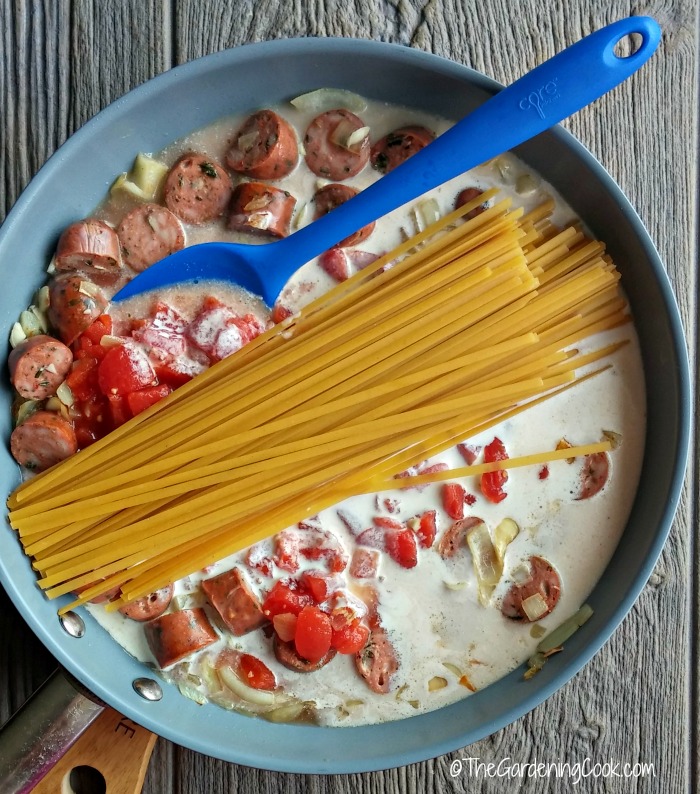 add cream, tomatoes and fettuccine noodles